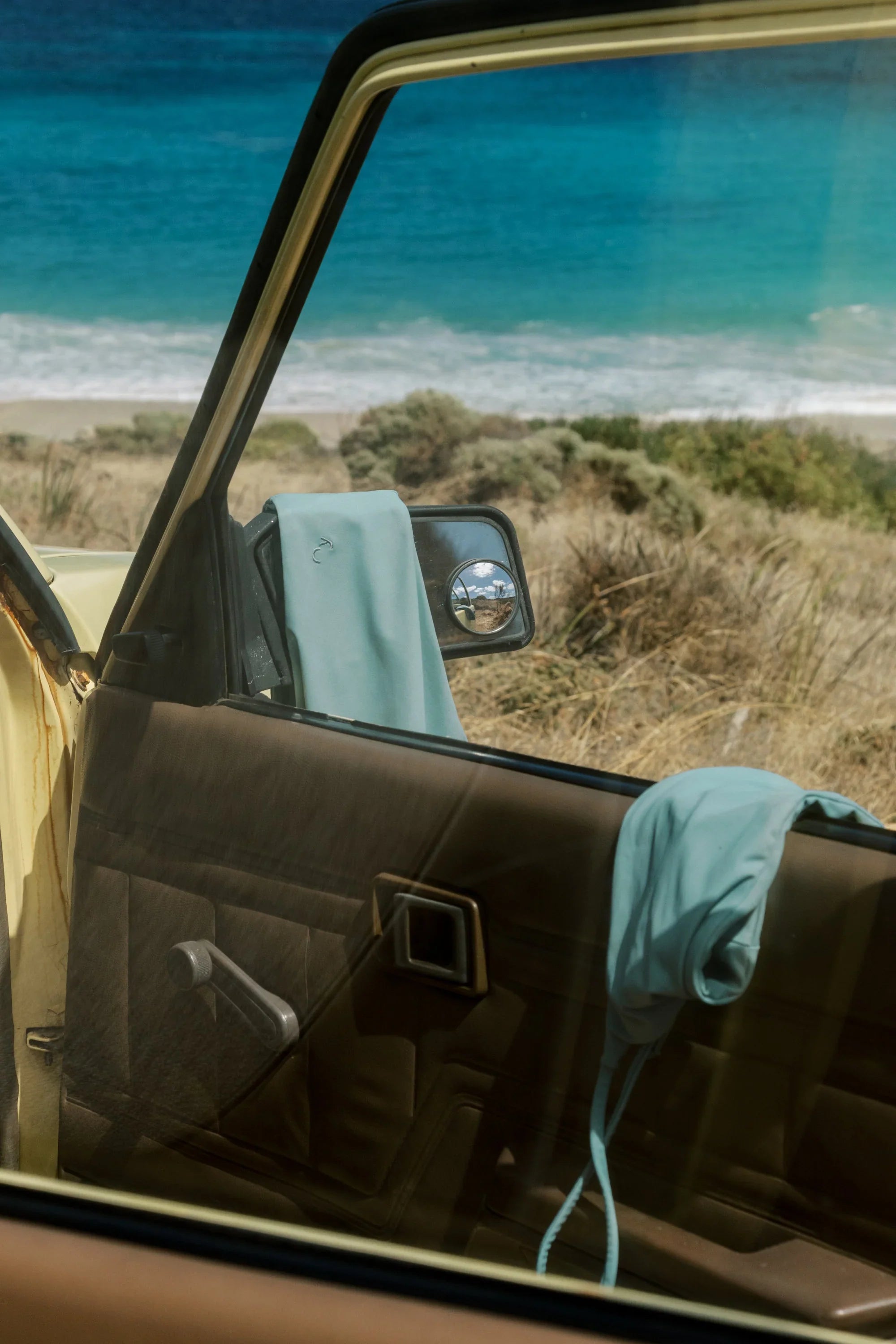 Car door open with a view of a beach and ocean